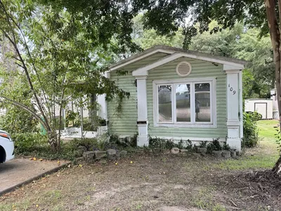 Tree-lined mobile home community with well-spaced units creating a village-like atmosphere, featuring both newer and...