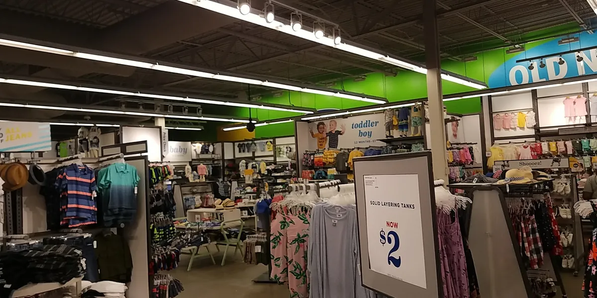 Bright, organized clothing displays at Old Navy Monroe with family apparel sections, sale signage, and wide aisles for...