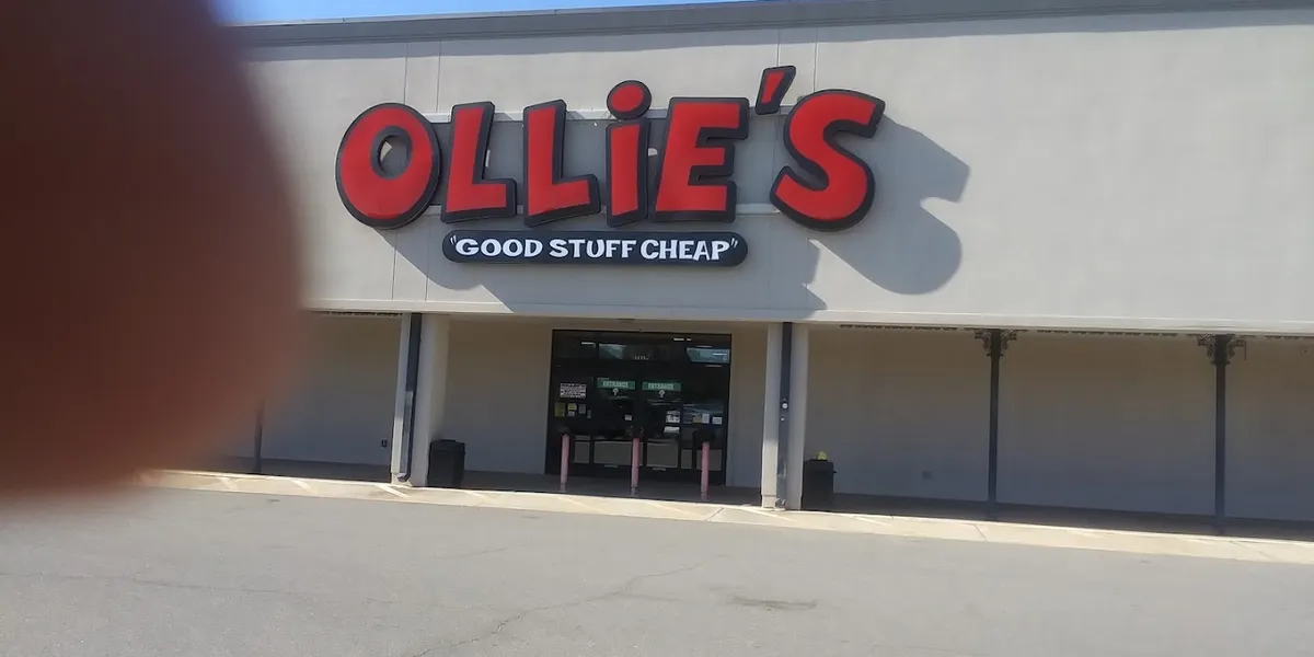 Warehouse-style discount store with packed aisles of diverse merchandise, colorful signage, and shopping carts navigating...