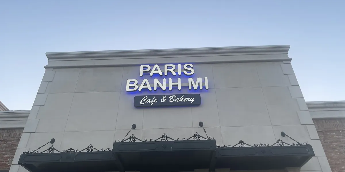 Modern Vietnamese café with Asian-futuristic decor, featuring colorful bubble waffles and pho bowls amid K-pop music and...