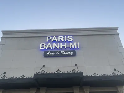 Modern Vietnamese café with Asian-futuristic decor, featuring colorful bubble waffles and pho bowls amid K-pop music and...