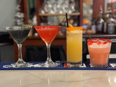 Intimate bar space with mood lighting, comfortable seating, and a sophisticated atmosphere where bartenders craft...