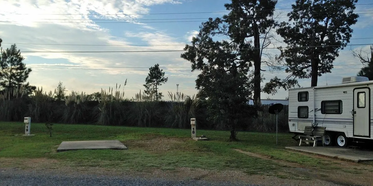 Practical RV park with neat rows of hookup sites, clubhouse building, and minimal landscaping, situated in a quiet area...