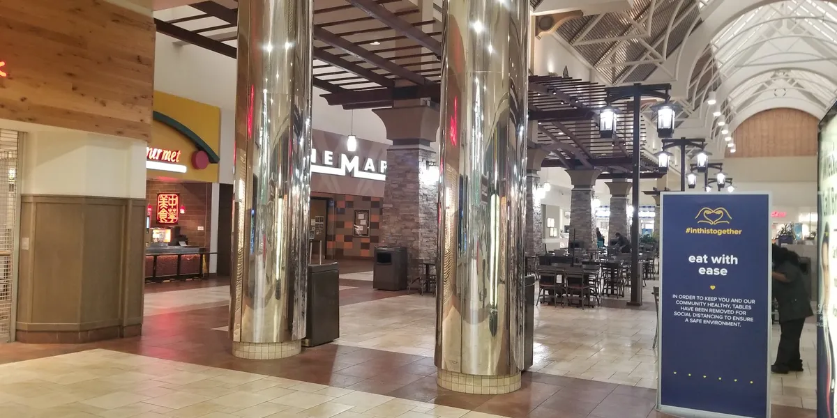 Compact food court with scattered seating areas inside Pecanland Mall, featuring a limited selection of fast food...