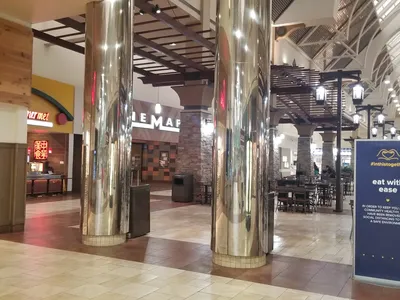 Compact food court with scattered seating areas inside Pecanland Mall, featuring a limited selection of fast food...