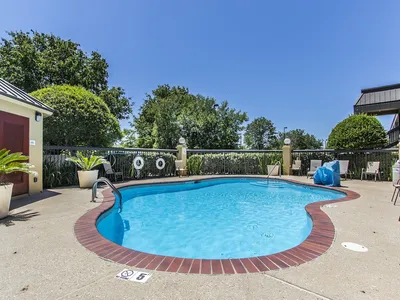 Modest roadside Quality Inn with exterior parking lot, displaying a two-story building structure with standard room...