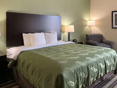 Roadside Quality Inn & Suites featuring outdoor pool area, parking lot, and standard two-story hotel exterior with room...