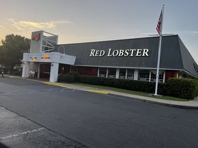 Spacious seafood restaurant with booth seating, nautical decor, and serving stations displaying fresh seafood platters...