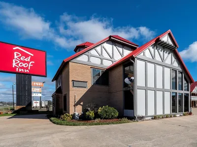 Exterior view of Red Roof Inn Monroe showing the entrance, parking area, and standard two-story motel-style building with...