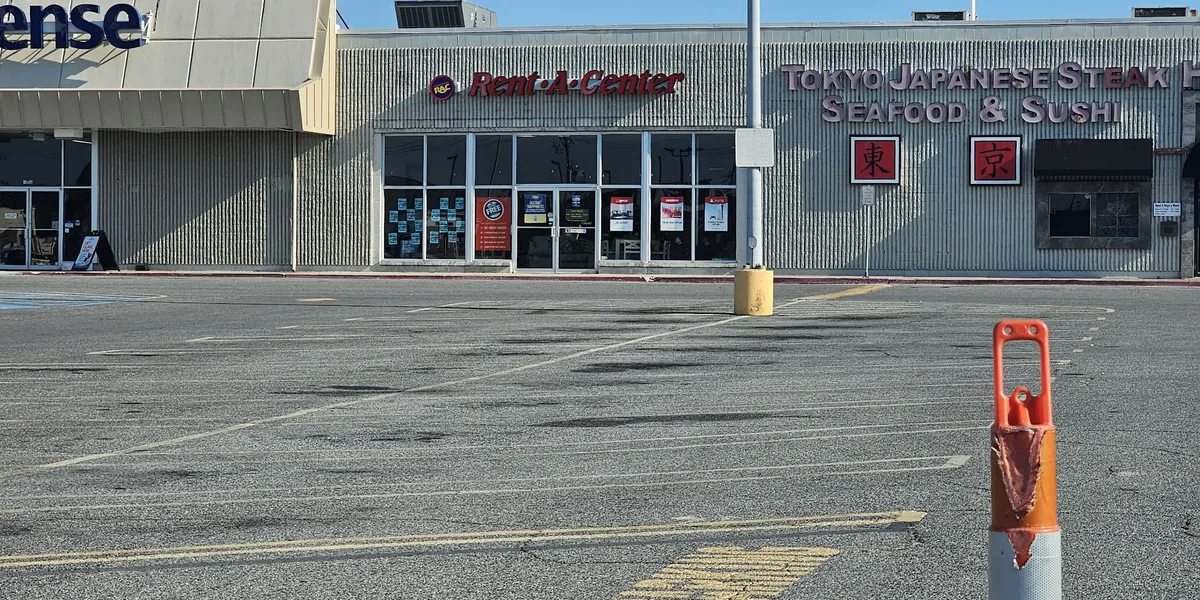 Organized showroom displaying furniture and household items available for rent, with clean aisles and product displays in...