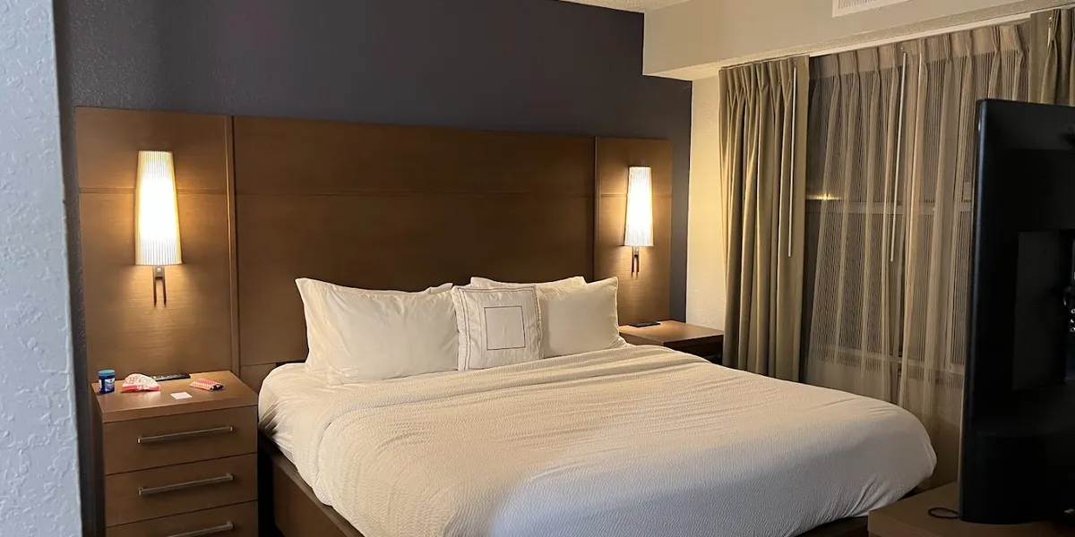 Multi-story Residence Inn exterior with outdoor pool area, parking lot, and entrance featuring Marriott branding on...