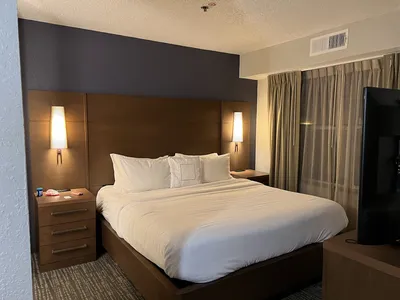 Multi-story Residence Inn exterior with outdoor pool area, parking lot, and entrance featuring Marriott branding on...