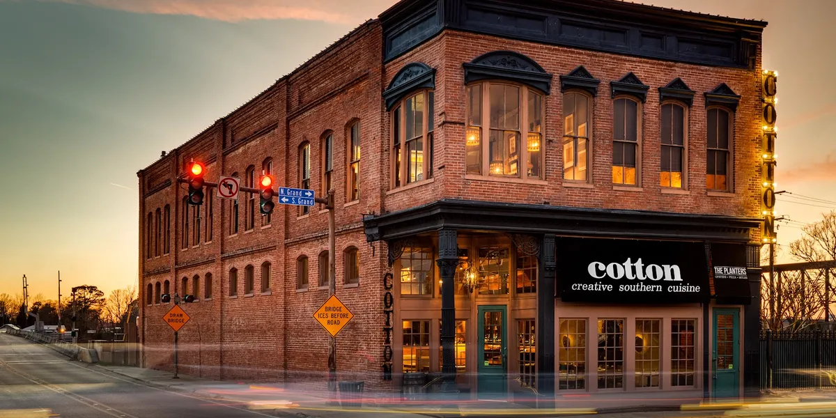 Historic restaurant with wooden floors, bar seating, and classic dining space showcasing vintage architectural details in...