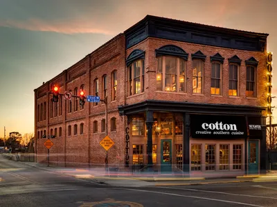 Historic restaurant with wooden floors, bar seating, and classic dining space showcasing vintage architectural details in...