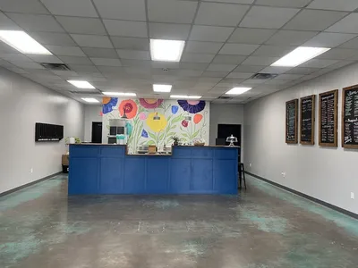 Bright counter-service tea shop with standing room only, featuring colorful drink displays and a casual grab-and-go...