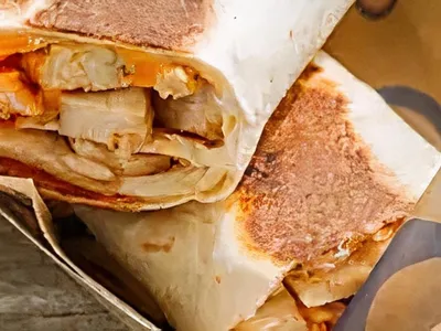 Compact sandwich shop with counter service featuring menu boards of specialty wraps and sandwiches popular with the lunch...