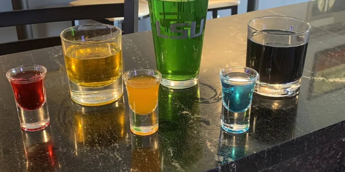 Clean bar interior with outdoor seating area where bartenders serve drinks and burgers to a mix of friendly regulars and...