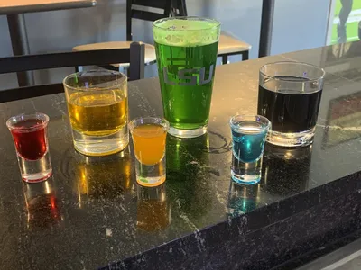 Clean bar interior with outdoor seating area where bartenders serve drinks and burgers to a mix of friendly regulars and...