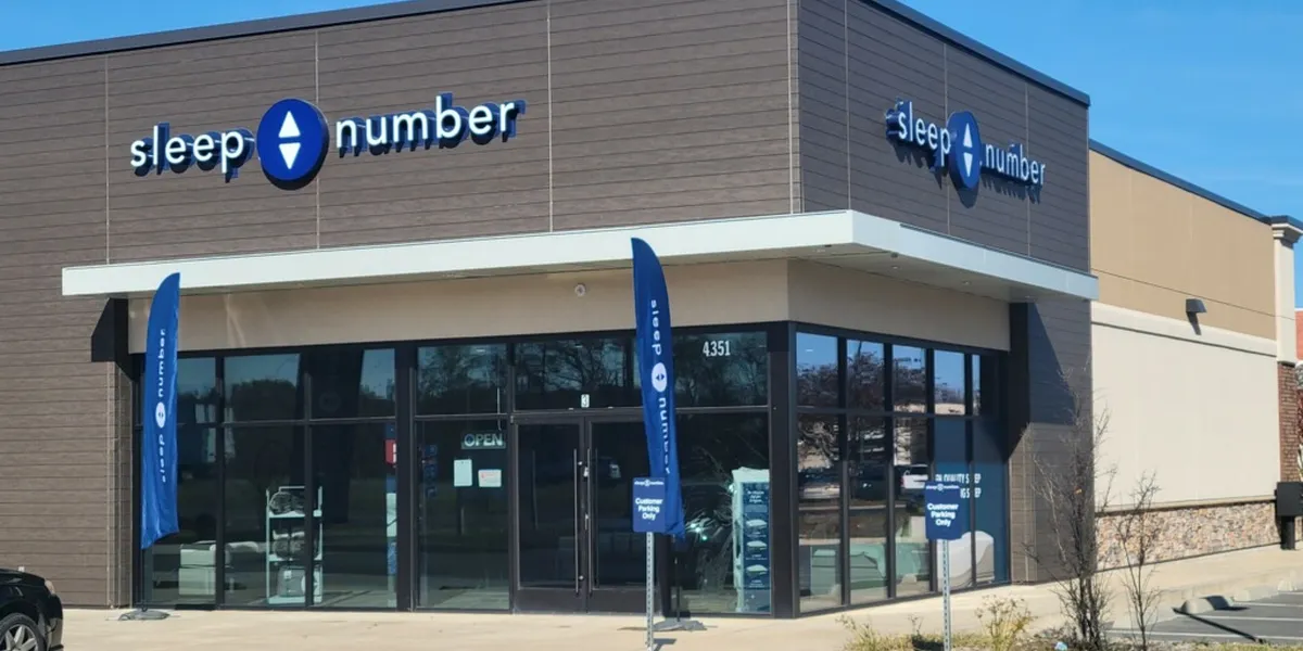 Spacious Sleep Number showroom displaying various adjustable mattress models with testing stations and digital comfort...