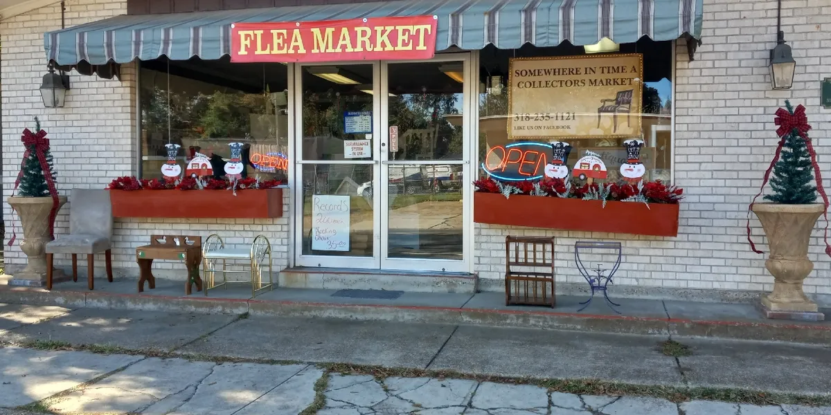 Expansive indoor collectors market with rows of diverse vintage items, antiques and collectibles displayed throughout a...