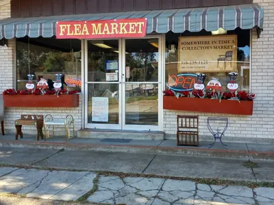 Expansive indoor collectors market with rows of diverse vintage items, antiques and collectibles displayed throughout a...