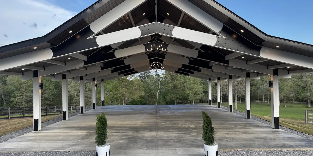 Rustic barn venue with exposed wooden beams, large barn doors, and an open floor plan surrounded by scenic outdoor photo...