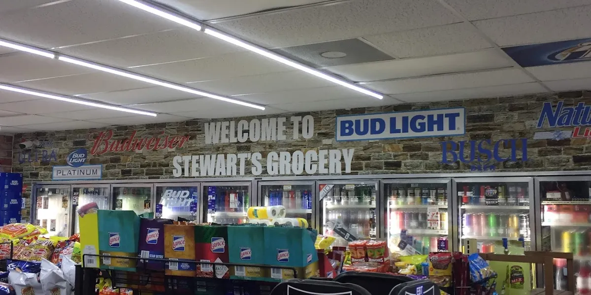 Neat, well-organized convenience store with a bustling deli counter and fresh seafood section, showing prepared food...