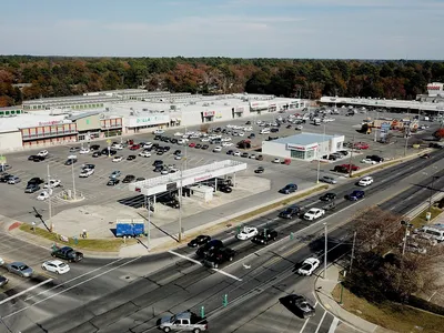 Exterior view of Sunshine Heights shopping mall with multiple storefronts including Brookshire Foods and Russell's Hair...