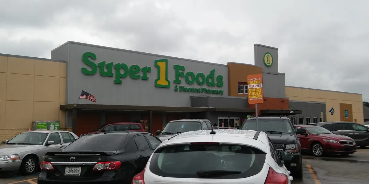 Bright, well-organized grocery store with neatly stocked shelves, wide aisles for wheelchair access, and clearly marked...