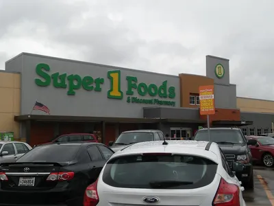 Bright, well-organized grocery store with neatly stocked shelves, wide aisles for wheelchair access, and clearly marked...