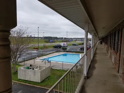 Exterior view of Super 8 motel with parking lot entrance doors, simple furnishings, and dated decor in a convenient...