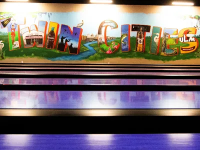 Spacious indoor entertainment complex with colorful obstacle courses, bowling lanes, and play areas filled with active...