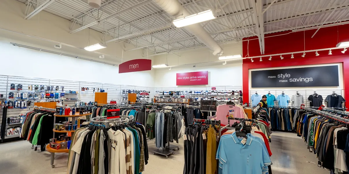 Bright, well-maintained T.J. Maxx store with organized clothing racks, shoe displays, and home furnishing section at...