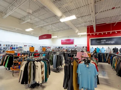 Bright, well-maintained T.J. Maxx store with organized clothing racks, shoe displays, and home furnishing section at...