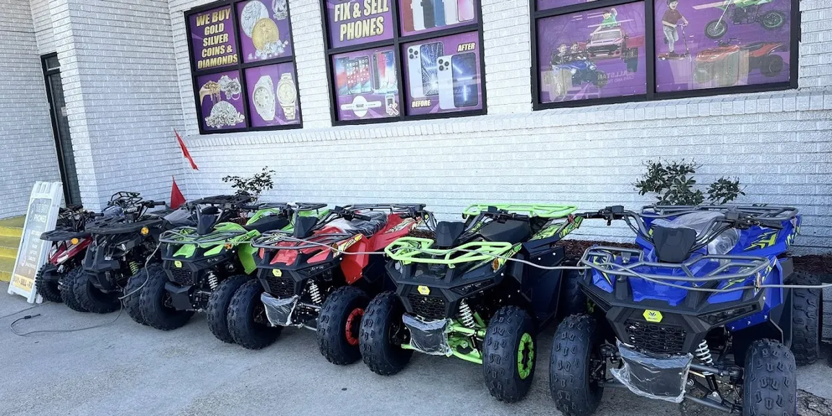 Bright retail counter displaying jewelry buying scales and phone repair tools, with glass cases of tech accessories and...