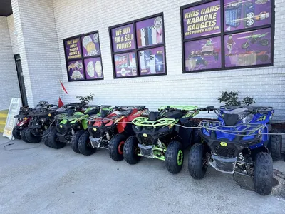 Bright retail counter displaying jewelry buying scales and phone repair tools, with glass cases of tech accessories and...