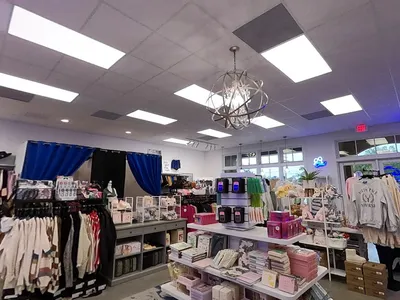Bright, well-organized clothing boutique with trendy apparel displays, unique accessories, and a clean, modern shopping...