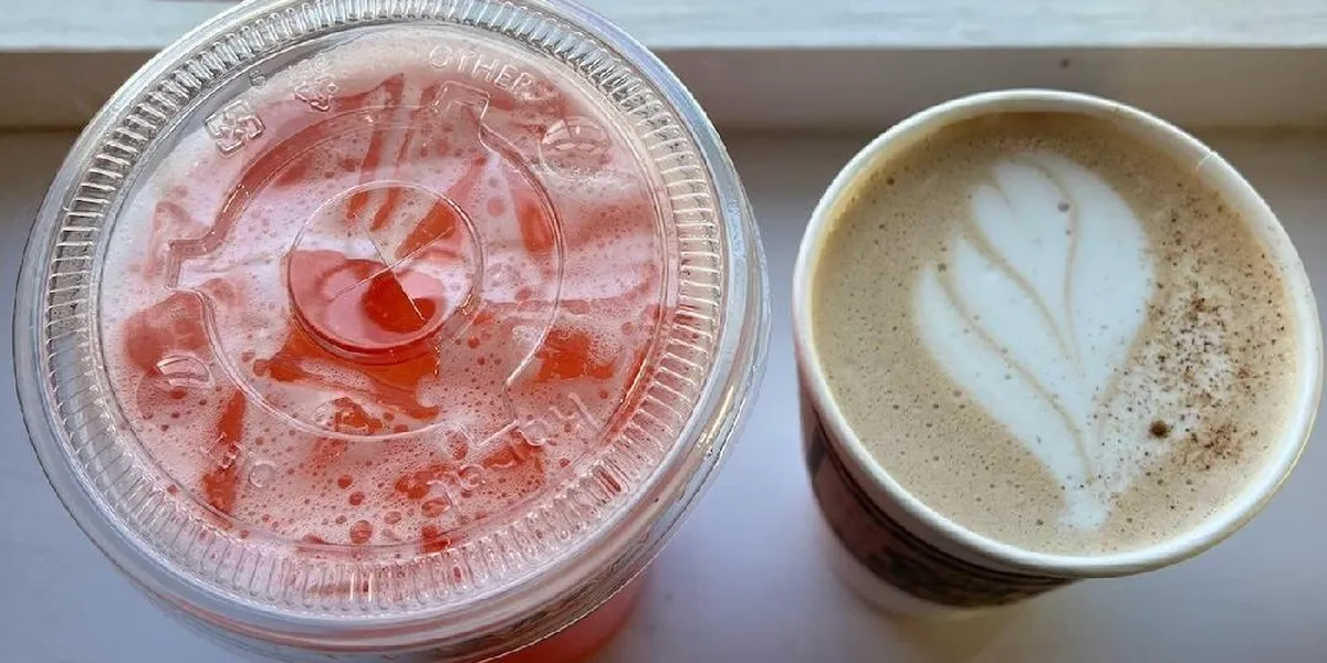 Intimate coffee shop with outdoor seating area where customers enjoy specialty drinks while dogs relax at their feet.