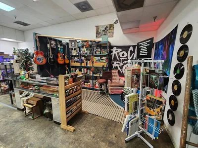 Sprawling indoor flea market with dozens of vendor booths displaying collectibles, furniture, and vintage items in a...