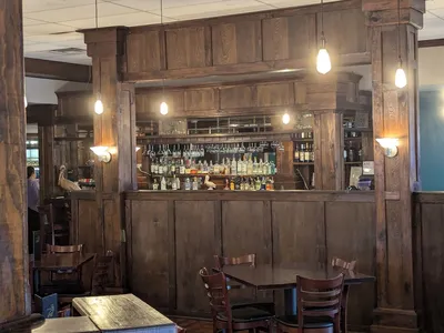 Elegant dining space at The Fat Pelican with carefully arranged tables, subtle lighting, and a sophisticated bar...