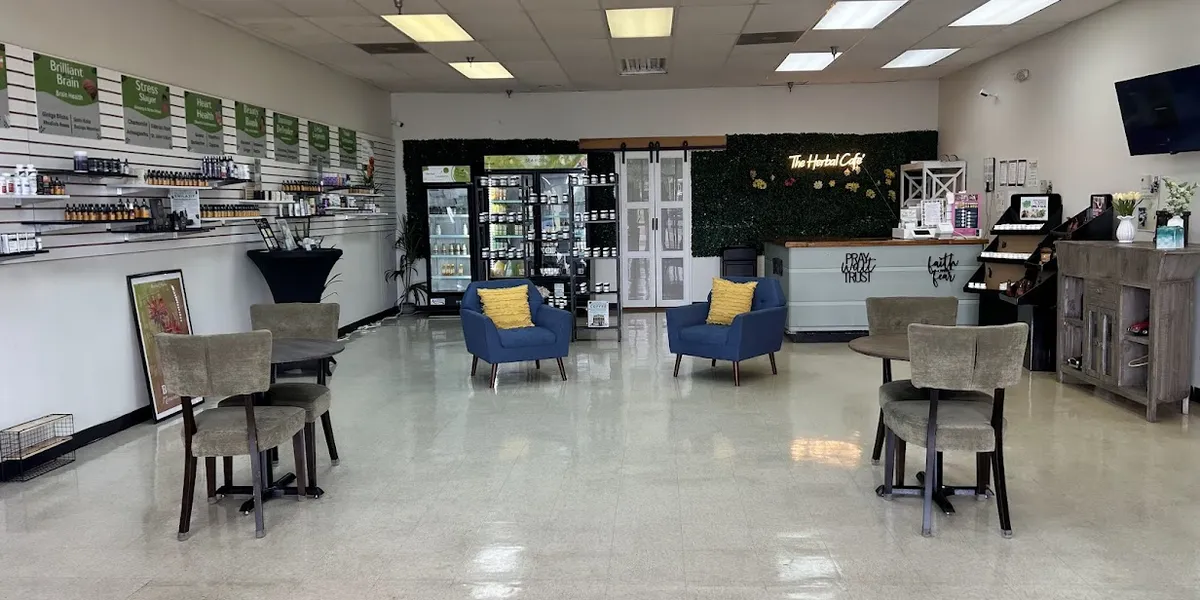 Bright wellness hub with tea and supplement displays, outdoor seating area, and colorful lemonade counter featuring sea...