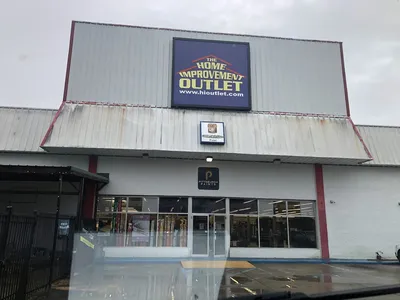 Comprehensive home improvement warehouse with organized lumber selection, diverse building materials, and staff assisting...