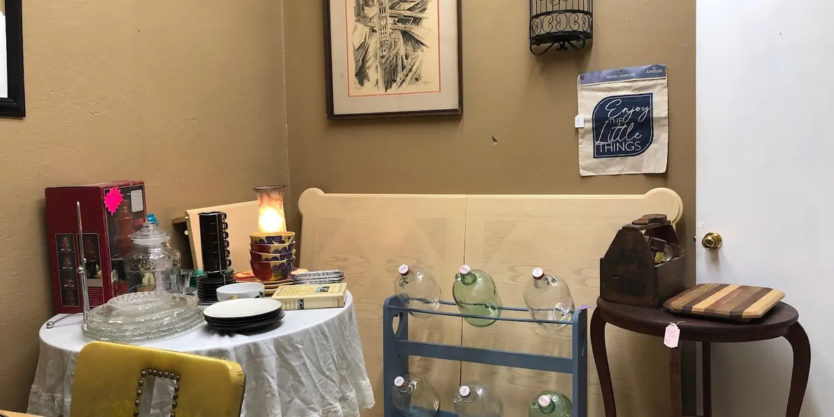 Cozy antique shop with diverse collectibles and furniture pieces arranged in browsable displays, creating a treasure-hunt...