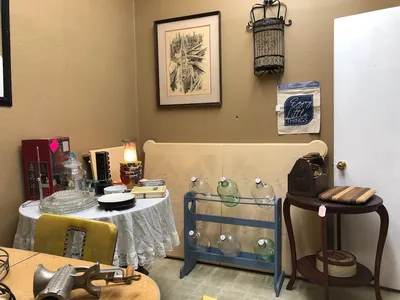 Cozy antique shop with diverse collectibles and furniture pieces arranged in browsable displays, creating a treasure-hunt...