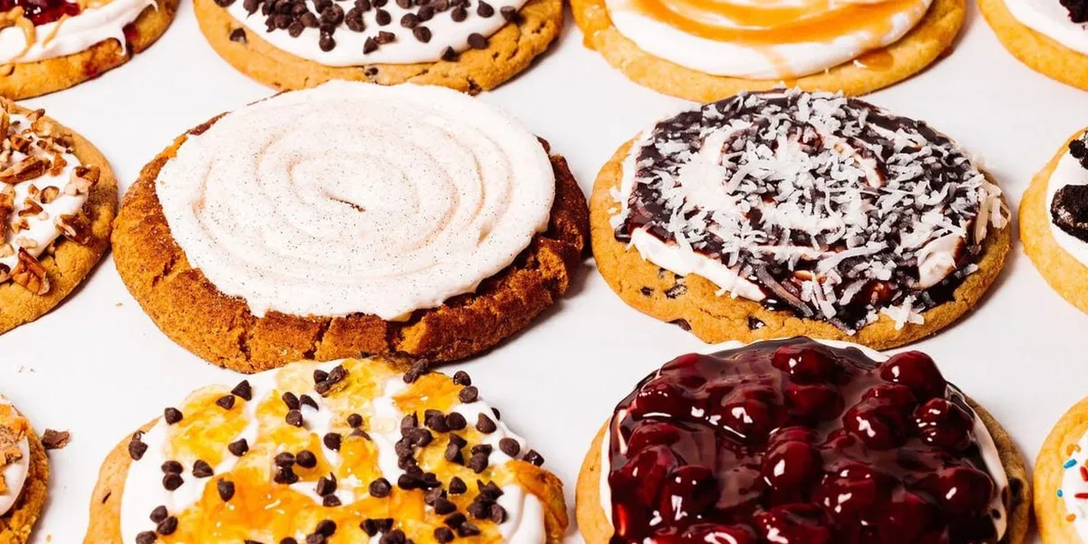 Bright, clean bakery counter displaying colorful cobblers and puddings with comfortable seating for families celebrating...