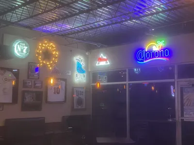 Bustling college bar with outdoor seating area, live music stage, and standing-room floor space where patrons gather for...