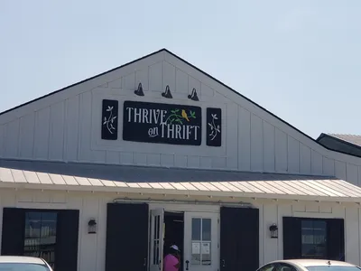 Neatly arranged thrift store with organized merchandise displays, color-coded tag sections, and a bright, clean shopping...