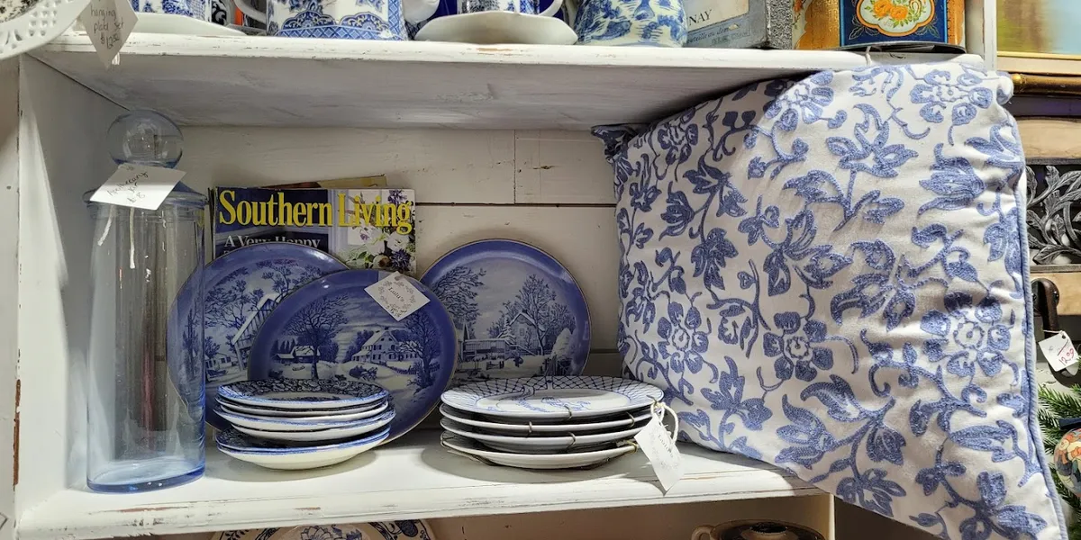 Sprawling antique store with rooms of vintage collectibles, figurines, and old tools arranged in browse-friendly displays...