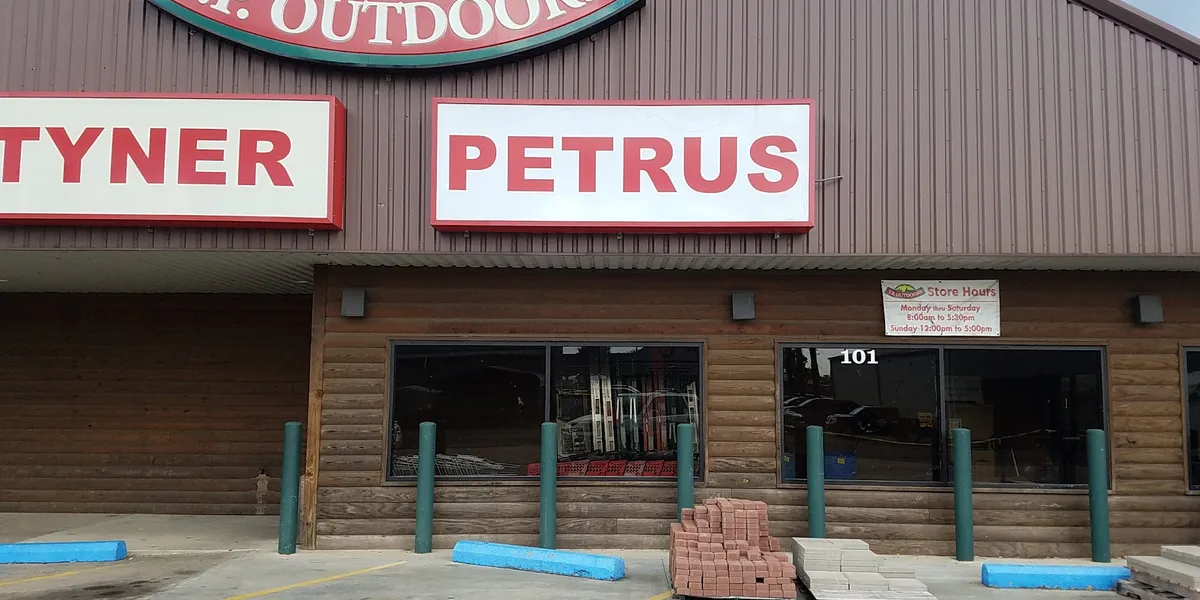 Organized aisles of a traditional hardware store with neatly arranged tools, home supplies, and sporting goods in a...