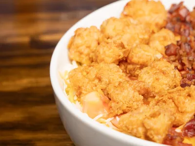 Dimly lit lounge with DJ booth, standalone pool table, bar area serving drinks, and outdoor seating space on Desiard...